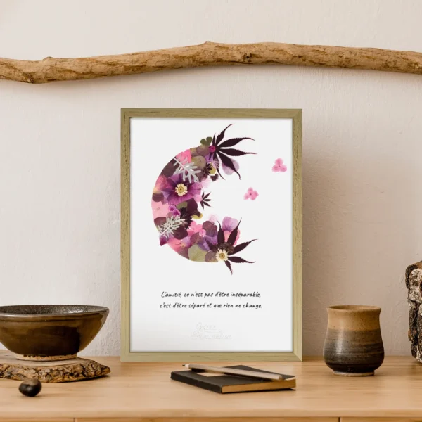 demi lune en herbier de couleur rose et de la forme de lune ouverte avec citation et cadre bois clair