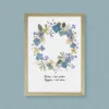 Couronne végétale en fleurs pressées, nuances de bleu et de vert, cadre bois clair et phrase inspirante