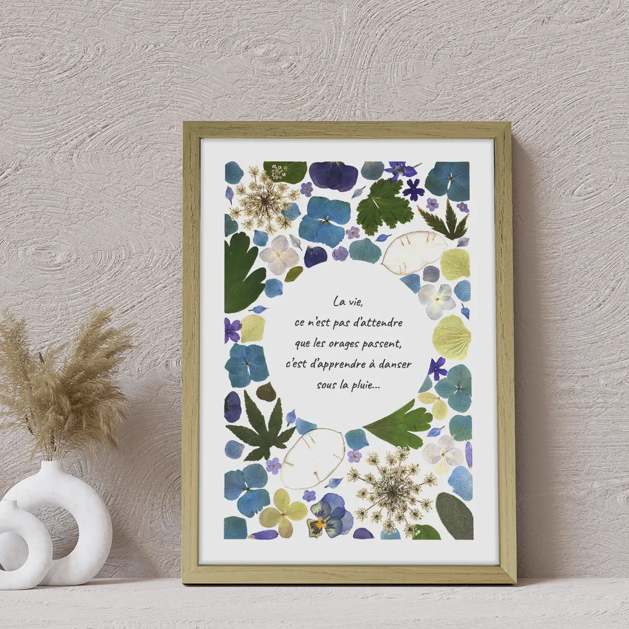 Herbier mural floral ajouré avec fleurs bleues et feuillages verts citation centrée cadre bois clair