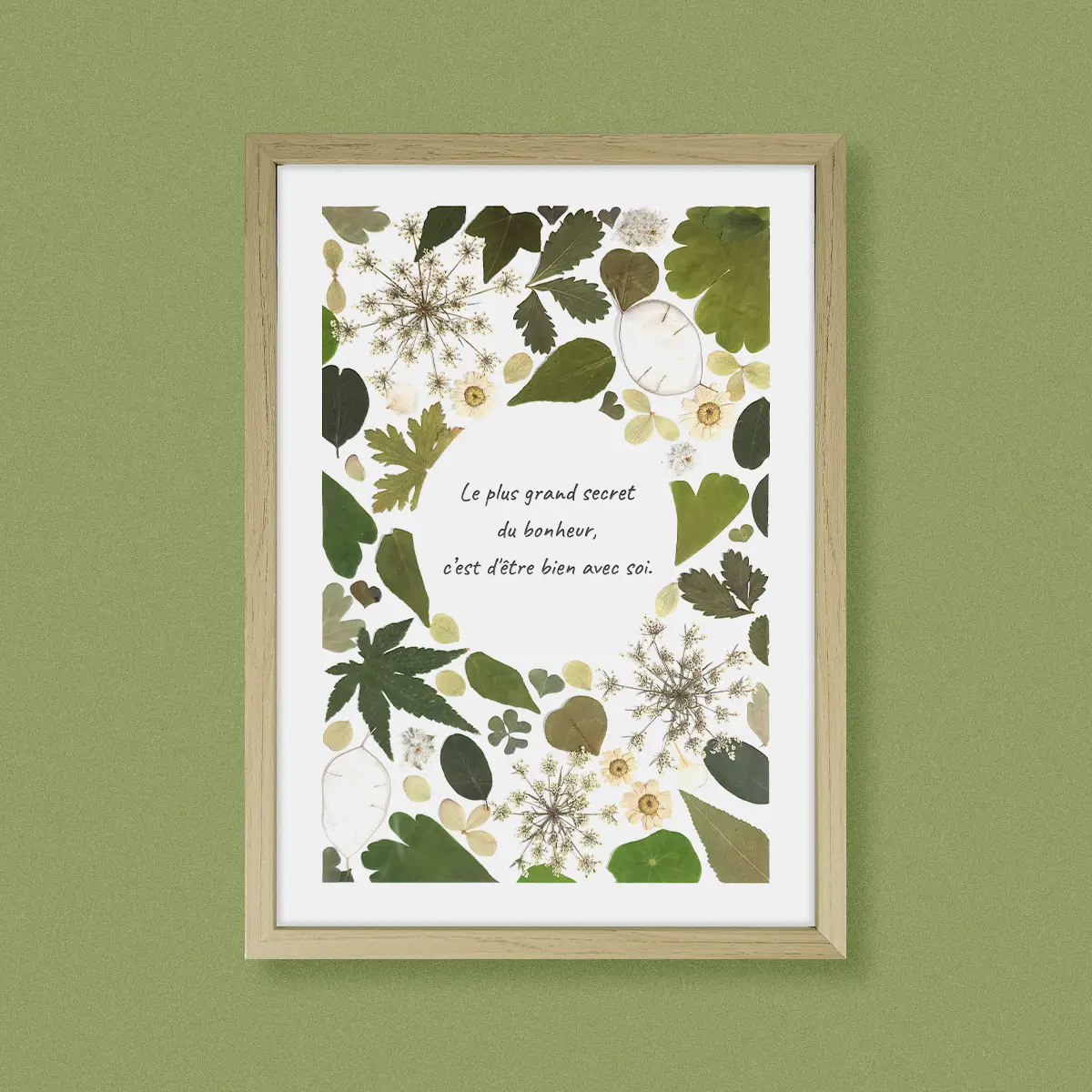 herbier végétal fleurs et feuillage pressées verts, composition naturelle et sauvage, citation centré cadre bois clair