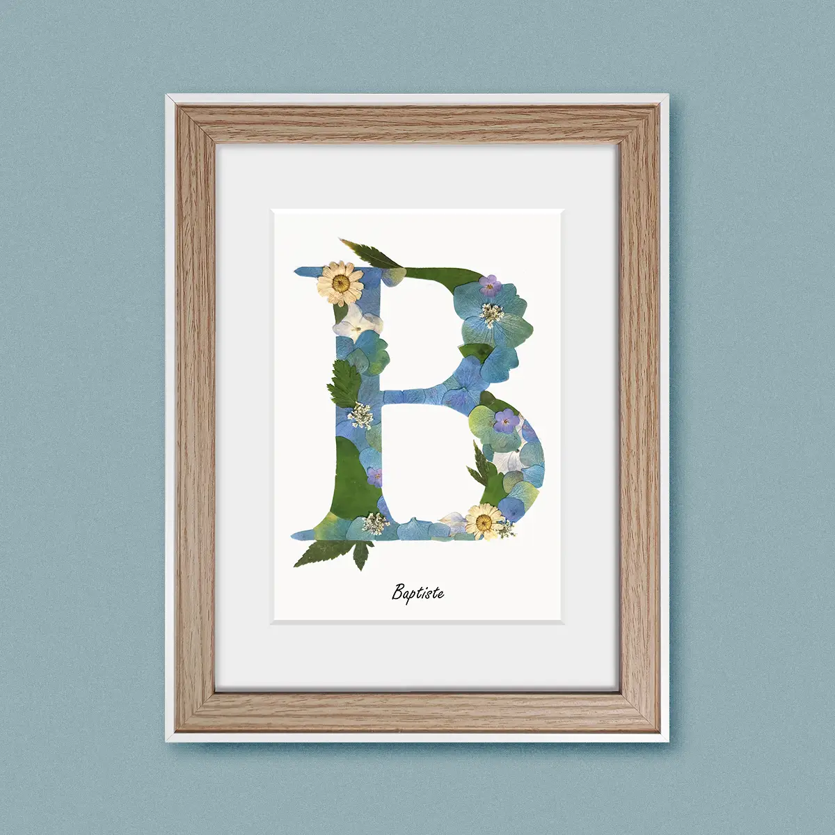 décoration herbier lettre aux teintes bleues et vertes sur cadre en bois clair